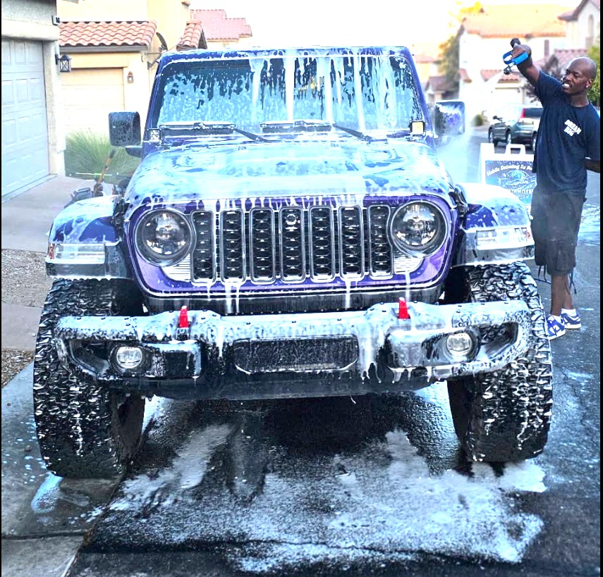 Keep Them Clean technician foaming a purple Jeep Rubicon in a Las Vegas driveway